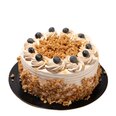 Blueberry coffee crunch cake with cream frosting, granola crumble topping, and fresh blueberries on a round layered cake.